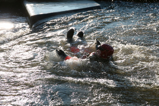 Practising defensive swimming in fast moving water during swift water training