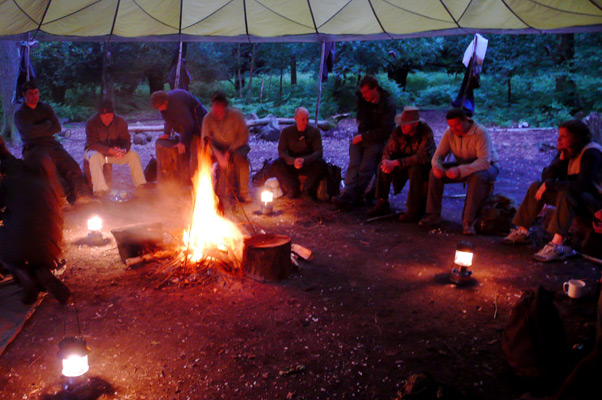 A group around the main camp fire under the parachute