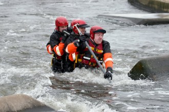 Negotiating a river crossing as a team using a stout pole for support